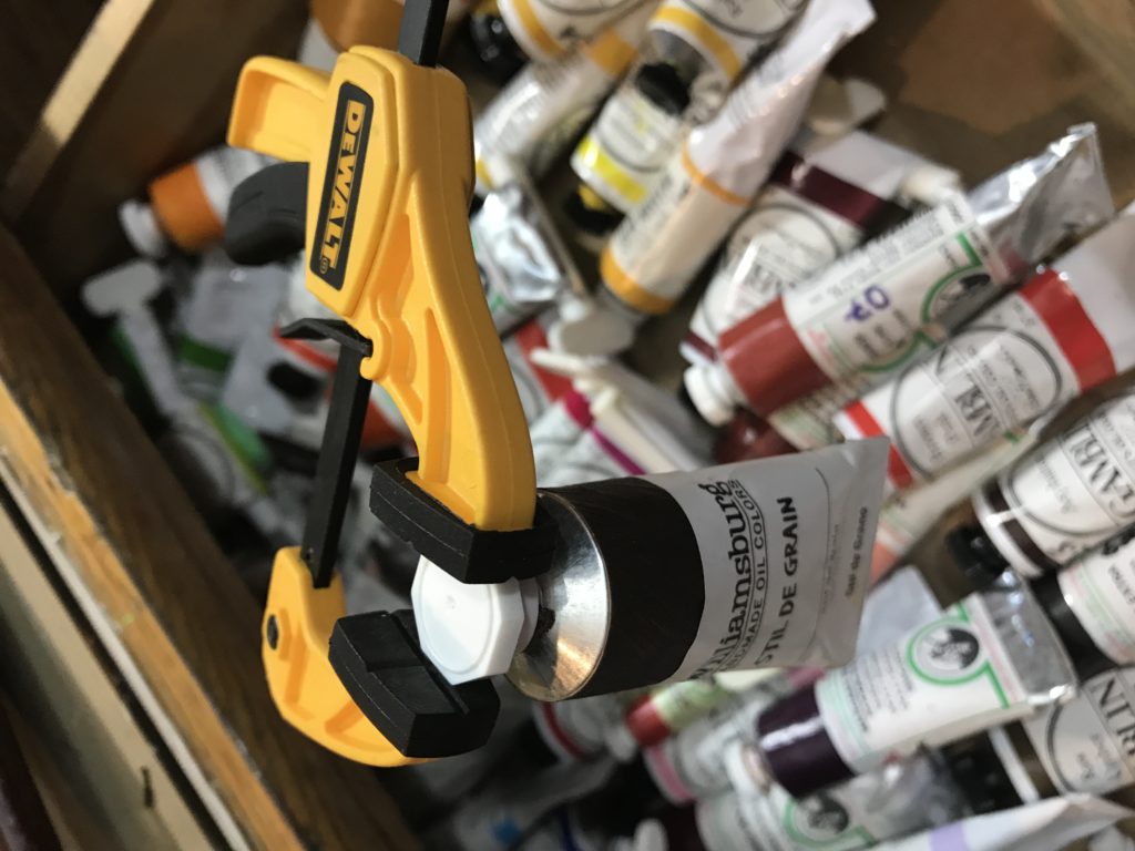 Clamp removing paint tube cap